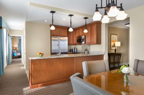 an open kitchen and dining room with a wooden table at The Royal Sonesta Chase Park Plaza St Louis in Saint Louis