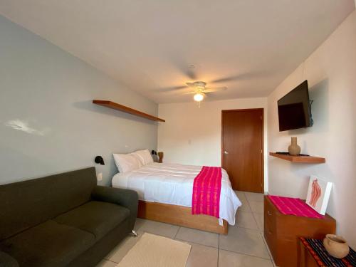 a small bedroom with a bed and a couch at Cozy Apartment close to Andares @serra in Guadalajara