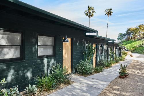 a black building with a door and plants on the side at Hotel June Malibu in Malibu