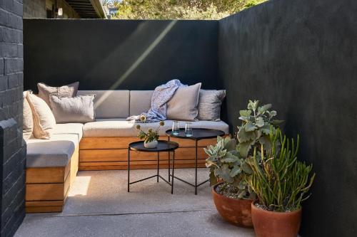 a patio with a couch and two tables with plants at Hotel June Malibu in Malibu