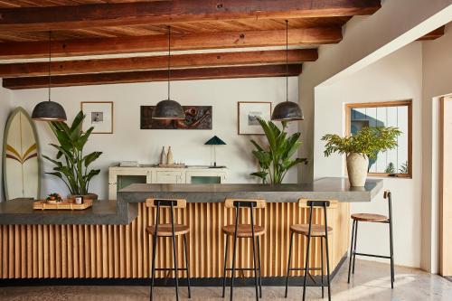 a kitchen with a large counter with stools at Hotel June Malibu in Malibu
