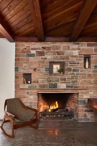 a brick fireplace with a chair in front of it at Hotel June Malibu in Malibu