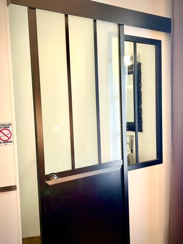 a black door with a window in a room at Hôtel Paul Riquet in Béziers