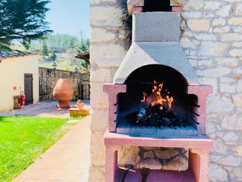 a stone oven with a fire in a yard at Agriturismo Borgo Il Bonagino in Radda in Chianti