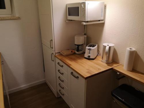 eine Küche mit einer Arbeitsplatte mit einer Mikrowelle und einem Aounter in der Unterkunft Sonnige 60m² Ferienwohnung für 5 Personen in Bad Lauterberg