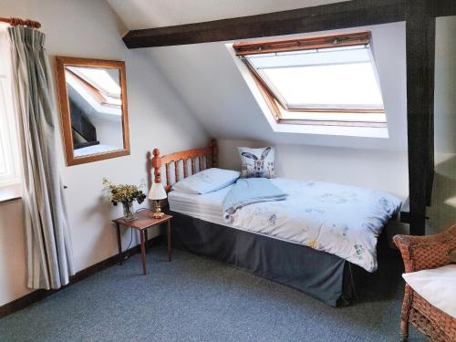 a bedroom with a bed and two windows at The Coach House in Bridgwater