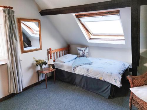 Un dormitorio con una cama y dos ventanas. en The Coach House, en Bridgwater