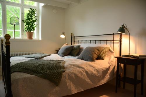 a bedroom with a bed and a table and a window at Grevlunda skola in Vitaby