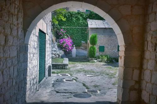 an archway in a stone building with a yard at Stone house Castellum in Kaštela