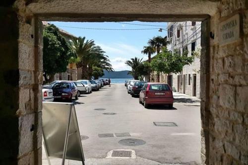 a view of a street with cars parked on the road at Stone house Castellum in Kaštela