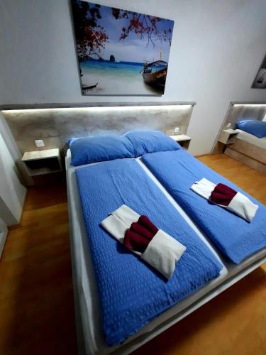a bed with blue sheets and red and white towels at VILLA NIKOLINA in Medulin