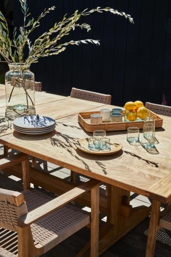 a wooden table with plates and glasses on it at Hotel June Malibu in Malibu
