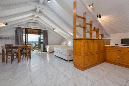 a bedroom with a bed and a table and a kitchen at Photographer's Apartments in Alikanas