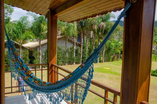 a hammock on the porch of a house at Recanto Meu Pedacinho de Chão in Visconde De Maua