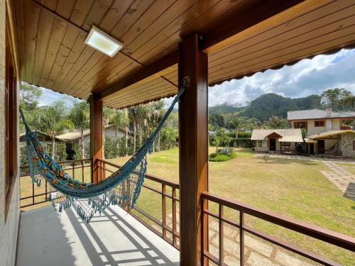 a hammock on the porch of a house at Recanto Meu Pedacinho de Chão in Visconde De Maua