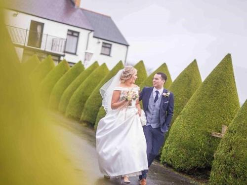 a bride and groom are walking down a path at Glendale Bed and Breakfast, Cushendall in Cushendall