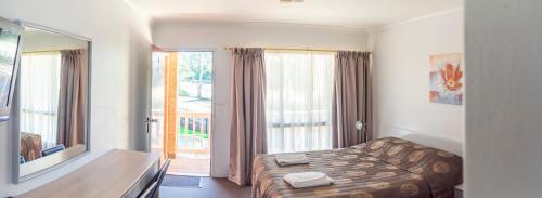 a bedroom with a bed and a large window at Sutherland Motel in Sutherland