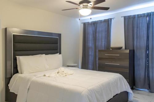 C'DaView Apartment Suite في خليج مونتيغو: غرفة نوم مع سرير مع مروحة سقف وخزانة