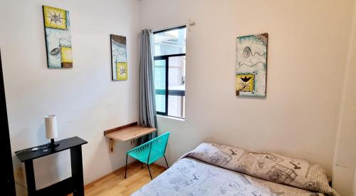 a bedroom with a bed and a desk and a window at HOM Roma in Mexico City