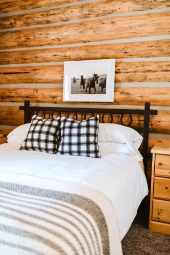 a bed in a room with a wooden wall at Teton Cabins in Moran