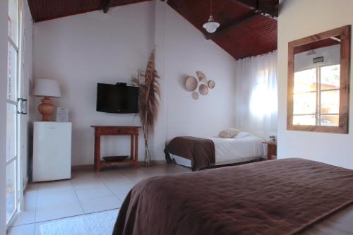 a bedroom with a bed and a television in it at Hospedagem Fazenda Nova América in Brotas