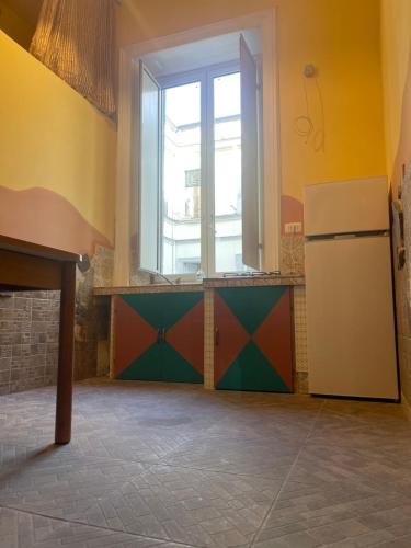 a kitchen with a refrigerator and a window at A I R Garibaldi Apartment in Naples
