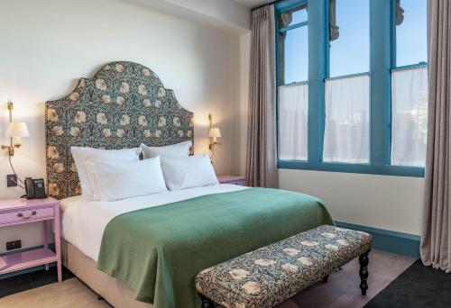 a bedroom with a large bed with a green blanket at The Observatory Hotel Christchurch in Christchurch