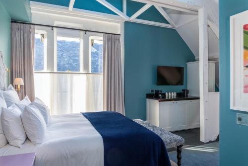 a bedroom with blue walls and a bed and a window at The Observatory Hotel Christchurch in Christchurch