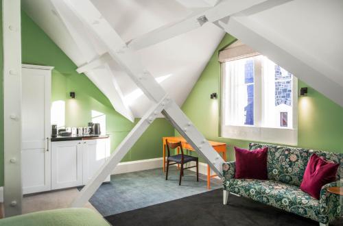 a living room with green walls and white beams at The Observatory Hotel Christchurch in Christchurch
