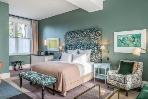 a bedroom with a large bed and a chair at The Observatory Hotel Christchurch in Christchurch