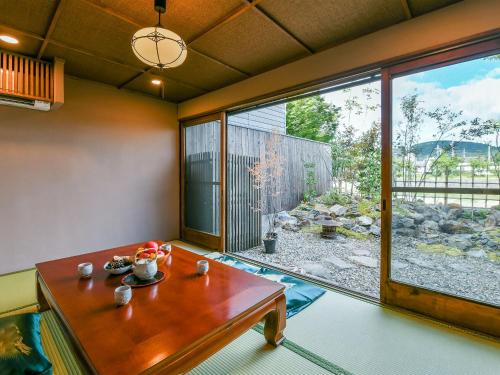 a living room with a table and a large window at 慶有魚·一心·鸭川(Kyotofish·Kamogawa)*鸭川畔独栋地暖百年町屋*京都仅十套 in Kyoto
