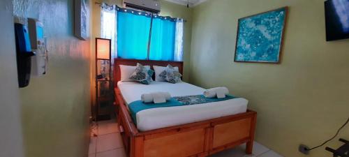 a small bedroom with a bed with blue curtains at Eastwood Escape in Nassau