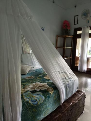 a bed with a canopy in a room at Brown Bamboo Guest house & jungle trekking orang-utan in Bukit Lawang