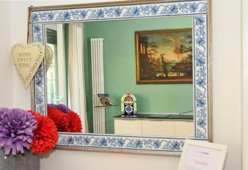 a mirror with a blue and white frame in a room at Sweet Home Parioli in Rome
