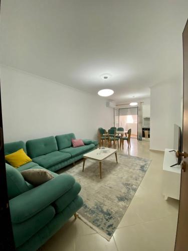 sala de estar con sofá verde y mesa en Lungo mare holiday apartment for family, en Vlorë