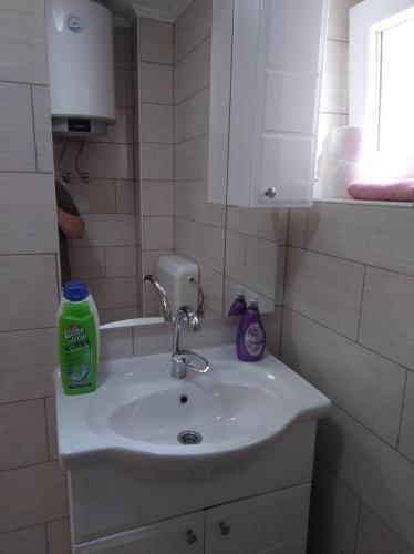 a bathroom sink with a bottle of soap on it at Studio by the river in Jajce