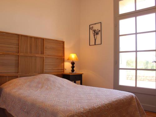 une chambre avec un lit et une grande fenêtre dans l'établissement Charmante maison en pierre, 6 couchages, proche plage et jardin arboré - Saint-Pierre-d'Oléron - FR-1-246A-126, à Saint-Pierre-dʼOléron