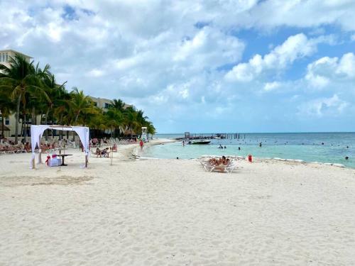 a beach with a gazebo and people in the water at Mexican Lagoon front Villa by CASA PARAISO in Cancún