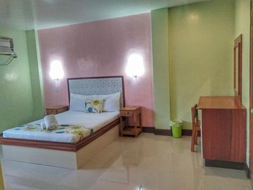 a bedroom with a bed in a room with green and pink walls at Calicoan Villa in Sarog