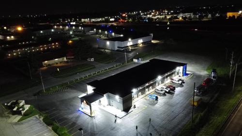 a large building with a parking lot at night at Days Inn by Wyndham Indianapolis East Post Road in Indianapolis
