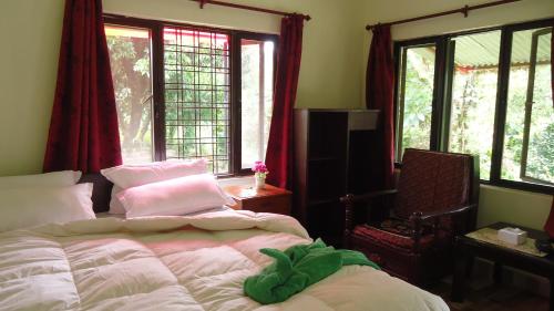 a bedroom with two beds in front of windows at Gurkha Lodge in Pokhara