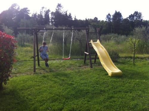 a man playing on a swing set in a yard at Azienda Agrituristica I Tre Casali in Magione