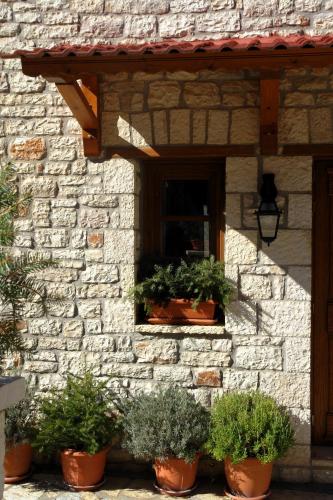 a stone building with potted plants in a window at Levanta in Méga Khoríon