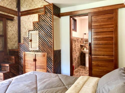 1 dormitorio con 1 cama y puerta de madera en Babaland, en New Agutaya