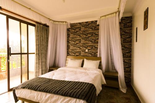 a bedroom with a bed and a brick wall at Room in BB - Kilihouse Is A Bb 4 Large Ensuite Double Bedrooms in Thika
