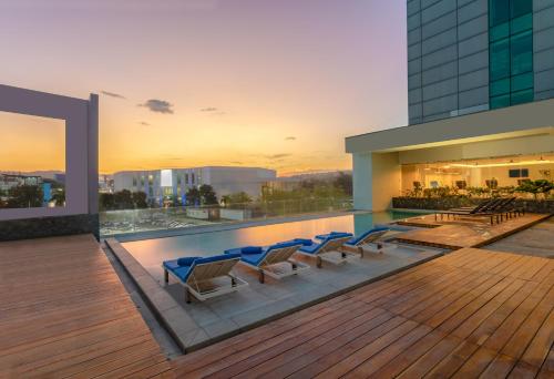 a rooftop pool with lounge chairs on a building at Hyatt Centric San Salvador in San Salvador