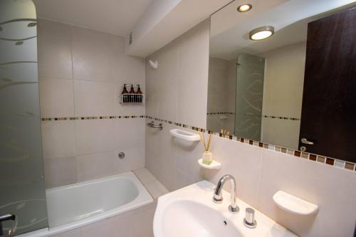 Un baño blanco con lavabo y espejo. en A & P, en Santa Fe