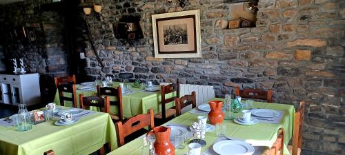 a dining room with two tables with green tablecloths at Cimas con historia in Fiscal