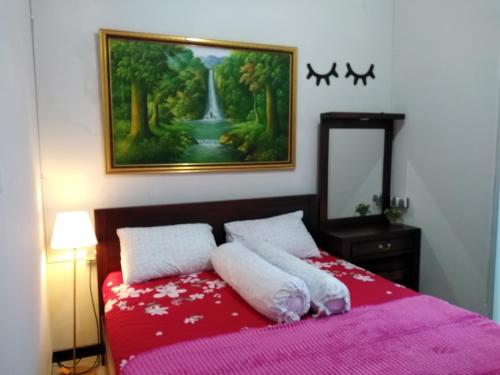 a bedroom with a red bed with a painting on the wall at Family Villa C37 Batu in Batu