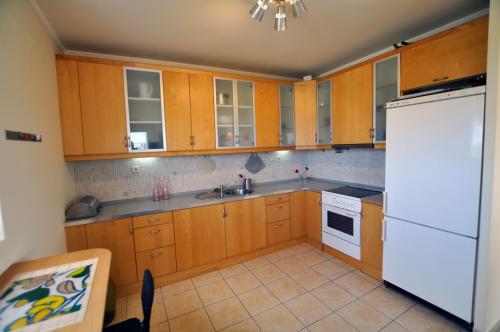 a kitchen with wooden cabinets and a white refrigerator at Xenos Villa 2 With 5 Bedrooms private swimming pool, near the sea in Tigaki